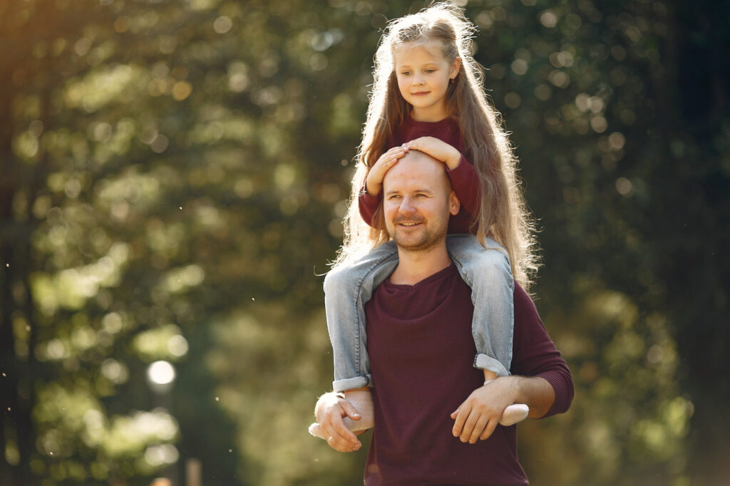 Vater trägt seine Tochter im Park auf den Schultern